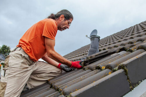Roofer replacing missing roof tile