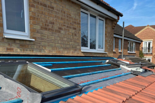 Tiles being laid on a new extension roof with Velux windows